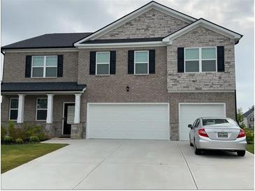 Beautiful two-story home featuring a brick and stone facade, and a two-car garage at 3378 English Elm Way, Loganville, GA 30052