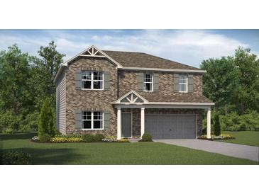 Charming two-story home with brick facade, gray shutters, manicured lawn and two car garage at 1209 Arnhem Dr, Hampton, GA 30228