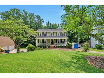 Inviting two-story home featuring a charming front porch and a lush green lawn, perfect for suburban living at 2165 Shillings Chase Nw Dr, Kennesaw, GA 30152