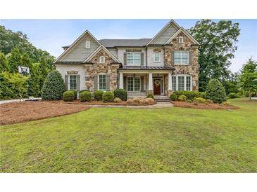 Beautiful two-story home featuring a stone facade, manicured lawn, and inviting front porch at 10 Nesbit Reserve Ct, Atlanta, GA 30350
