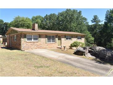 Charming brick ranch with green shutters, mature trees, and a long driveway at 3400 Scott Dr, Austell, GA 30106