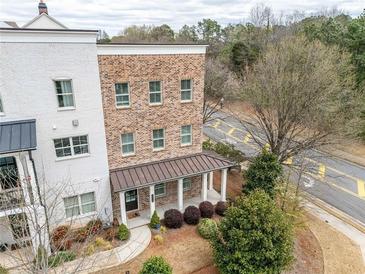 Charming brick townhouse with inviting covered porch and manicured front yard at 2026 Forte Lane, Alpharetta, GA 30009
