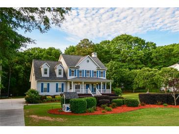 Charming two-story home with a welcoming front porch and professionally landscaped front yard at 855 Hood Rd, Fayetteville, GA 30214