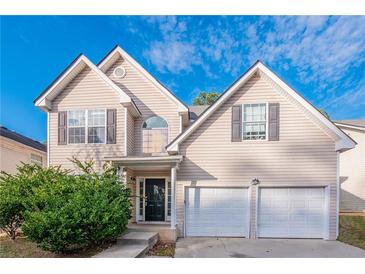 Charming two-story home featuring a two-car garage, inviting front porch, and manicured landscaping at 2931 Two Lake Cir, Atlanta, GA 30349