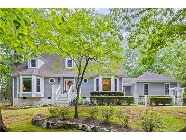 Charming two-story home with gray siding, manicured landscaping, and a welcoming front porch at 115 Leaf Lake Dr, Suwanee, GA 30024