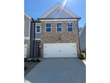 Two-story brick home with a two-car garage, grey siding and modern architectural details at 5623 Hislop Ln # 84, Mableton, GA 30126