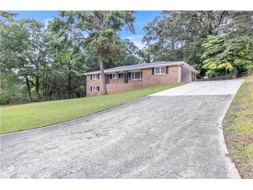Charming brick home featuring a long driveway and well-manicured lawn at 6243 David Sw Ln, Mableton, GA 30126