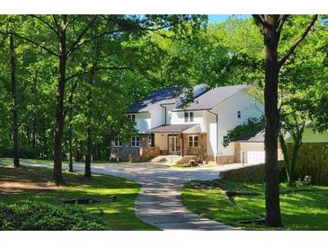 Charming two-story home with stone accents, a covered porch, and a welcoming driveway surrounded by lush landscaping at 2900 Orchard Sw Rd, Conyers, GA 30094