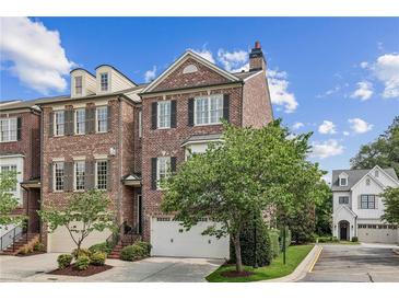 Charming brick townhome with a two-car garage and well-manicured landscaping at 565 Rose Garden Ln, Alpharetta, GA 30009