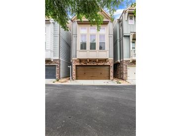 Charming townhome featuring stone accents and a two-car garage with inviting curb appeal at 3005 Devoncroft Se St, Smyrna, GA 30080