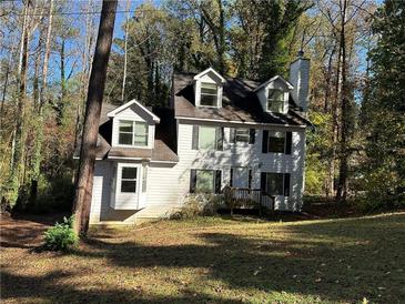 Two-story house with dormer windows surrounded by mature trees and foliage at 4232 Marjorie Rd, Snellville, GA 30039