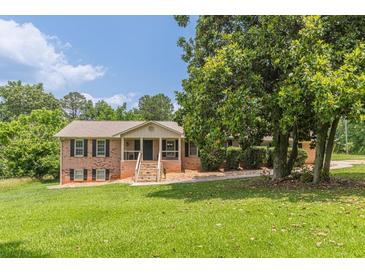 Charming single-story brick home with a landscaped front yard and inviting front porch at 7928 S Giles Rd, Douglasville, GA 30135