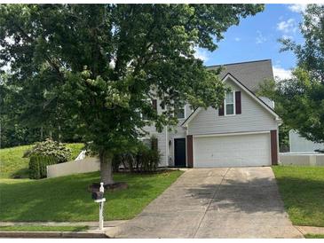 Charming two-story home featuring a spacious front yard, a two-car garage, and a driveway, perfect for suburban living at 1087 Yellow River Dr, Lawrenceville, GA 30043