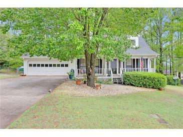 Charming home featuring a well-manicured front yard with mature trees and a welcoming front porch at 403 Rustic Ridge Cir, Lawrenceville, GA 30043