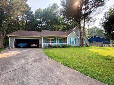 Charming single-Gathering home boasts a lush front lawn, attached garage, and a welcoming front porch at 4298 Hillview Dr, Acworth, GA 30101