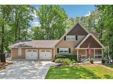 Charming exterior view of a two-story home with a large garage and well-manicured lawn at 890 Lake Dr, Snellville, GA 30039