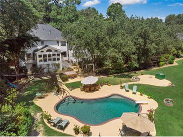 Aerial view of the private backyard pool and hot tub, surrounded by patio furniture and green landscaping at 2390 Sassafrass Ln, Powder Springs, GA 30127