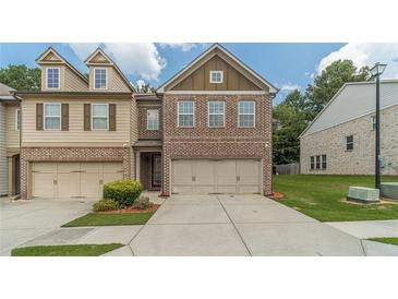 Charming brick townhome featuring a two-car garage and a well-maintained lawn with lush greenery at 3255 Clear View Dr, Snellville, GA 30078