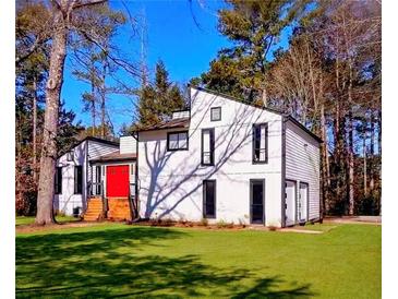 Modern home with a bright red door and nicely manicured lawn at 2645 Shadow Woods Circle Ne, Marietta, GA 30062