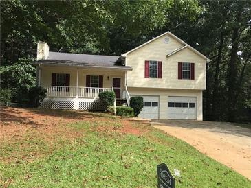 Charming two-story home with a cozy front porch, red shutters, and a two-car garage at 318 Bakers Bridge Cir, Douglasville, GA 30134