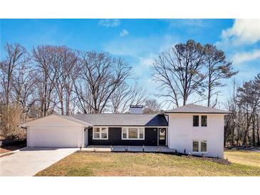 Charming renovated home with a two-car garage, black and white facade, and a lush green front lawn at 1536 Daffodil Drive, Marietta, GA 30062