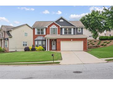 Charming two-story home with brick facade, two-car garage, manicured lawn and inviting curb appeal at 1657 Bradmere Ln, Lithia Springs, GA 30122