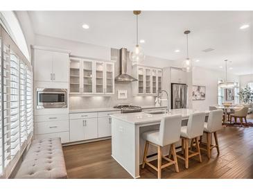 Modern kitchen features an island, stainless appliances, hardwood floors, and pendant lighting at 4202 Deming Cir, Sandy Springs, GA 30342