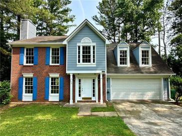 Charming two-story home with a well-manicured lawn, classic brick, and blue shutters at 4970 Clubgreen Smt, Stone Mountain, GA 30088