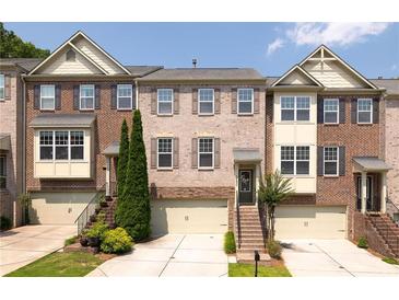 Charming brick townhome featuring a one-car garage and well-maintained landscaping at 3690 Lambert Ne Ln, Atlanta, GA 30319