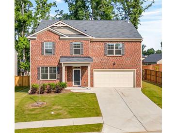 Charming two-story brick home featuring a well-manicured lawn and attached two-car garage at 4117 Flat Rock Pt, Stonecrest, GA 30038