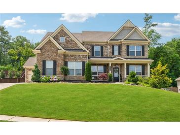 Inviting two-story brick home with a manicured lawn, black shutters, and charming front porch at 422 Silver Brook Dr, Woodstock, GA 30188
