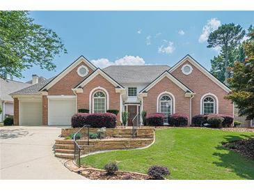 Beautiful brick home with a well-manicured lawn and a two-car garage at 10280 Medridge Cir, Johns Creek, GA 30022