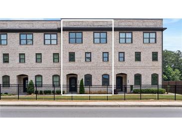 Charming brick townhome with a wrought iron fence and well-maintained landscaping at 3334 Swallowtail Ter, Duluth, GA 30096