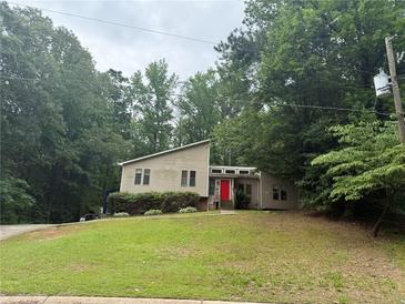 View of the home's exterior featuring a unique roof line and a red front door at 6649 Valley Hill Sw Dr, Mableton, GA 30126