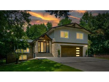 Beautiful home with a two-car garage, stone accents, and professional landscaping at sunset at 2116 Strasburg Ct, Atlanta, GA 30338