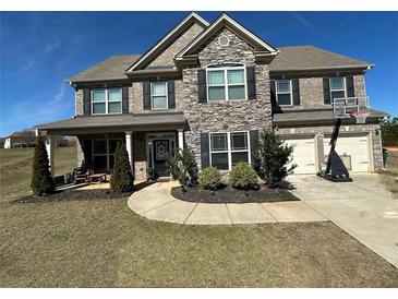 Charming two-story home with a stone facade, inviting front porch, and a two-car garage in a desirable neighborhood at 3227 Puritan Way, Mcdonough, GA 30252