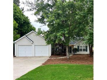 Charming one-story home with a two-car garage, mature trees, and well-maintained lawn at 1003 River Plantation Dr, Woodstock, GA 30188