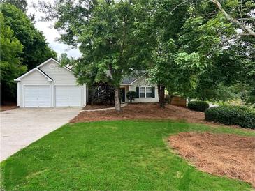 Charming single-Gathering home featuring a two-car garage and well-maintained front lawn at 1003 River Plantation Dr, Woodstock, GA 30188