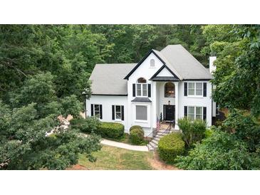 Charming two-story home boasts a black and white design, surrounded by lush landscaping and mature trees at 3290 Cherry Oak Ln, Cumming, GA 30041