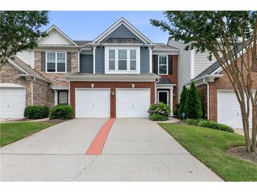 Charming townhome with a two-car garage, brick accents and well-maintained landscaping at 110 Finchley Dr, Roswell, GA 30076
