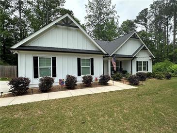 Charming one-story home featuring a landscaped yard, white siding, black shutters, and a welcoming front porch with rocking chairs at 2751 Pilgrim Mill Rd, Cumming, GA 30041