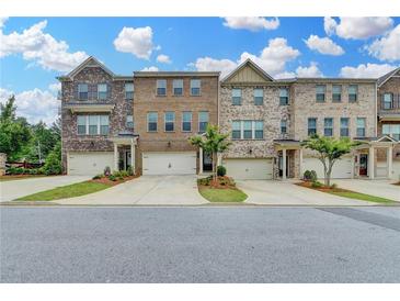 Attractive townhouse exteriors featuring brick facade, garages, driveways, and tidy landscaping at 3587 Hidden Valley Cir, Lawrenceville, GA 30044