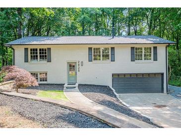 Charming home featuring painted brick, a well-manicured lawn, and an attached garage at 2825 Shea Sw Way, Marietta, GA 30060