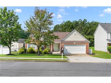 Charming one-story home with brick facade, manicured lawn, and two-car garage on a sunny day at 3589 Garden Manor Dr, Loganville, GA 30052