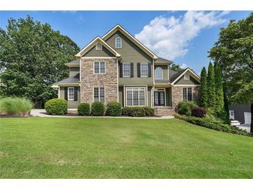 Charming two-story home with a stone and siding exterior and a beautifully manicured lawn at 203 Crescent Moon Way Way, Canton, GA 30114