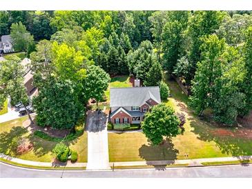 An attractive two-story brick home with a lush lawn and mature trees on a private, wooded lot at 1120 Bagwell Dr, Kennesaw, GA 30152