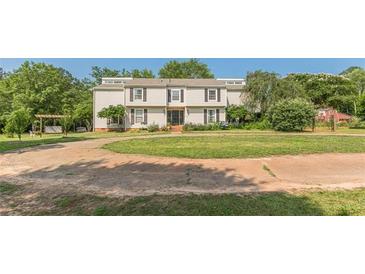 Expansive home exterior features a circular driveway and a spacious, grassy front yard with mature trees at 2229 S Van Wert S Rd, Villa Rica, GA 30180