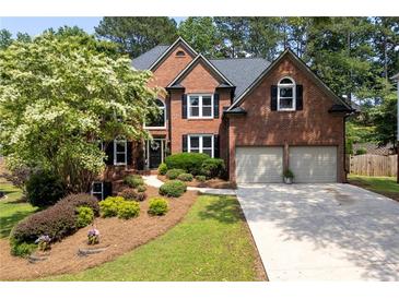 Charming brick home with a lush landscaped front yard and a two-car garage at 809 Hillcrest Ln, Woodstock, GA 30189