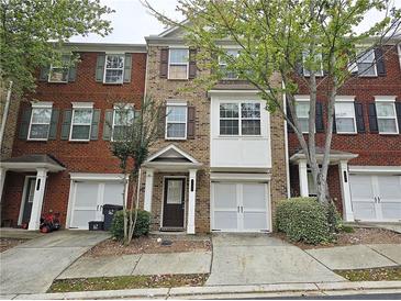 Brick townhouse with a front entrance, garage, and neatly maintained landscaping at 2104 Meadow Peak Rd, Duluth, GA 30097