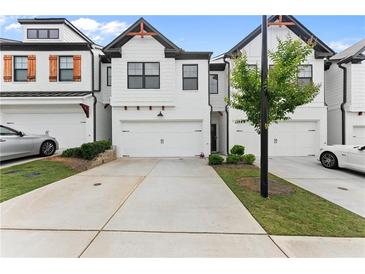 Charming townhome with a two-car garage, concrete driveway, and manicured lawn at 61 N Auburn Landing Pl, Auburn, GA 30011